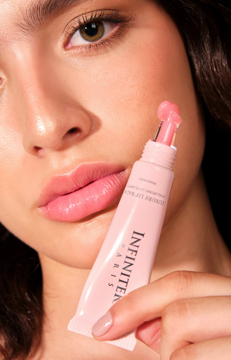 mujer modelo latina sosteniendo en la mano un luxury lip balm de infinitek paris, lindos ojos, voluminizador de labios